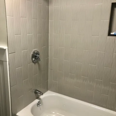 a bath tub sitting next to a white sink and a shower