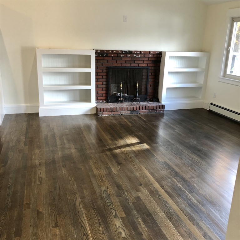 46 Legate Hill Road Leominster, MA 01453 - Photo 4 of 20 a view of an empty room with a fireplace and a window