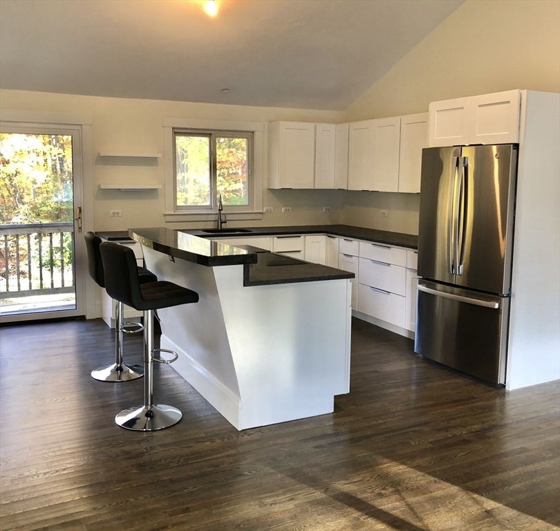 46 Legate Hill Road Leominster, MA 01453 - Photo 5 of 20 a kitchen with granite countertop a refrigerator a stove a sink cabinets and wooden floor