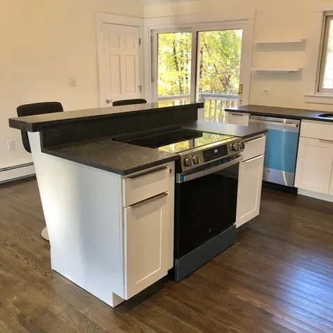 a kitchen with granite countertop a stove and a sink
