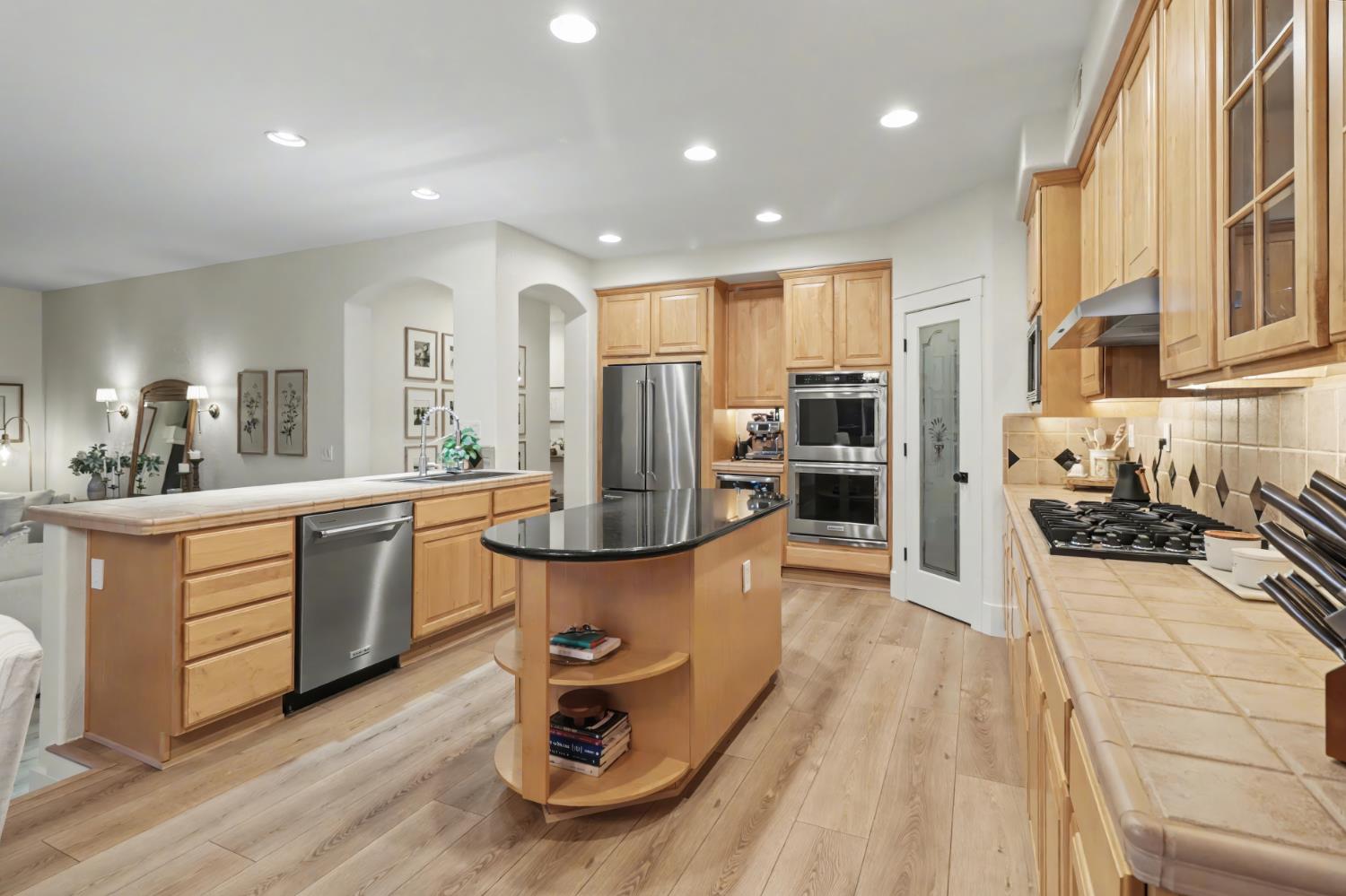 3835 Deer Ridge Lane Auburn, CA 95602 - Photo 25 of 79 a kitchen with stainless steel appliances kitchen island granite countertop a stove a sink a refrigerator and cabinets