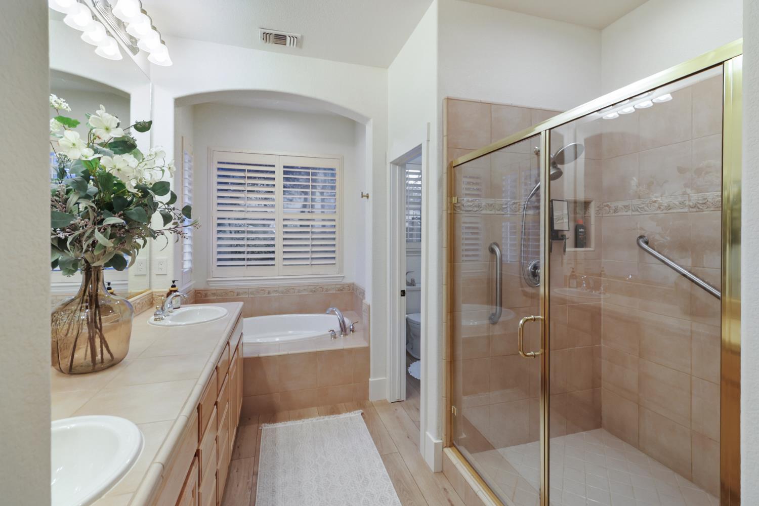 3835 Deer Ridge Lane Auburn, CA 95602 - Photo 36 of 79 a bathroom with a granite countertop sink a toilet and shower