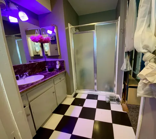 a kitchen with a checkered floor and white cabinets