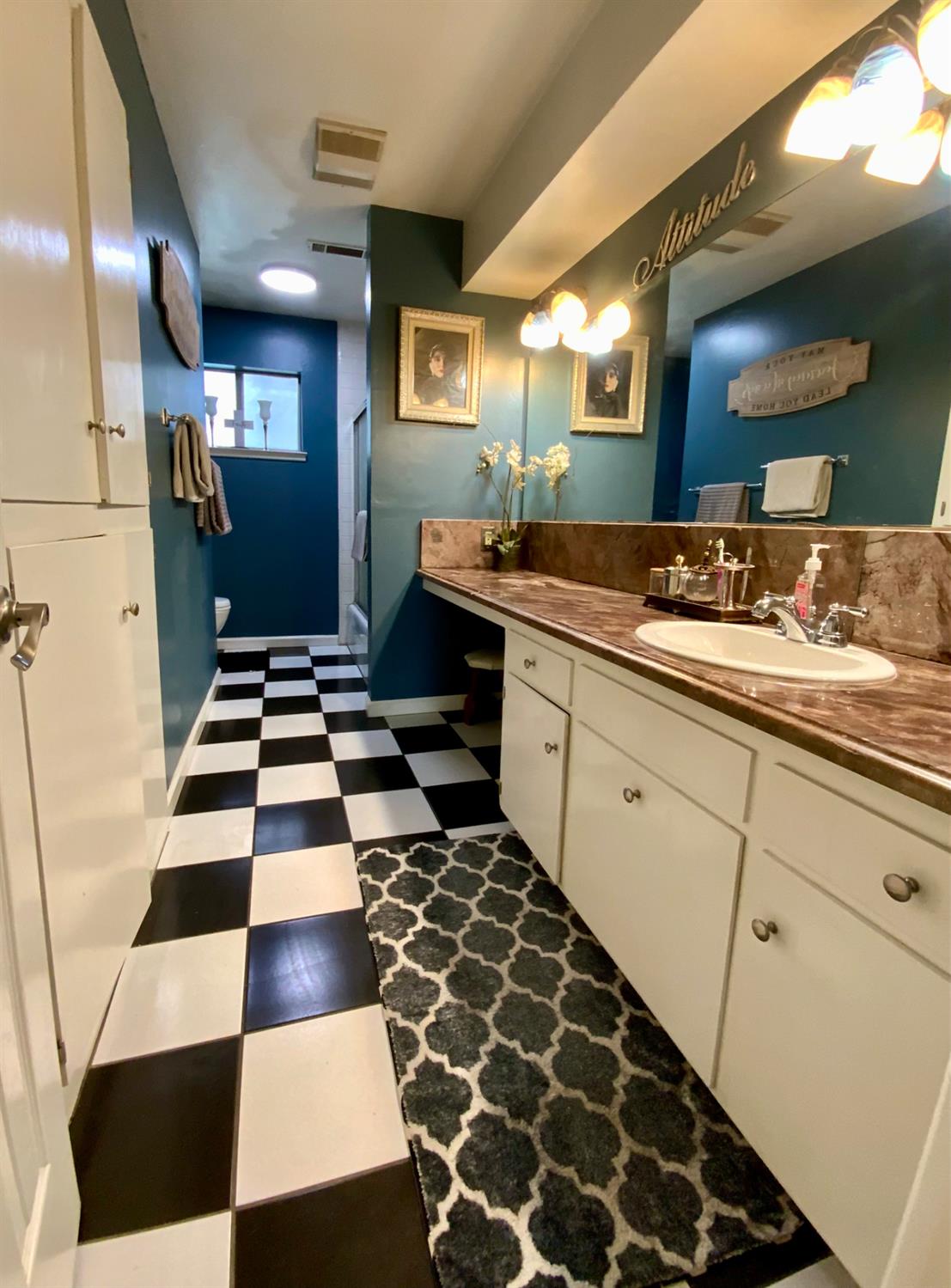 48833 Rock Point Road Oakhurst, CA 93644 - Photo 24 of 36 a kitchen with a checkered floor and white cabinets