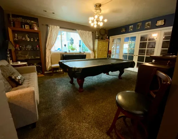 a living room with furniture a flat screen tv and kitchen view