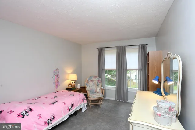 a bedroom with a bed and large windows