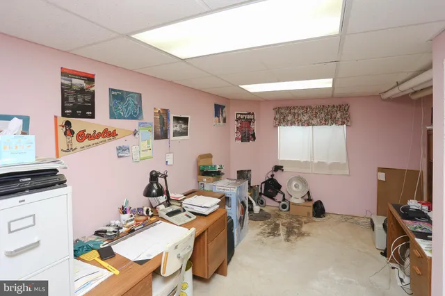 a work room with furniture a flat screen tv and a window
