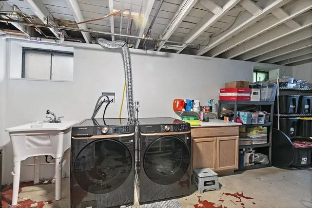 a utility room with sink dryer and washer