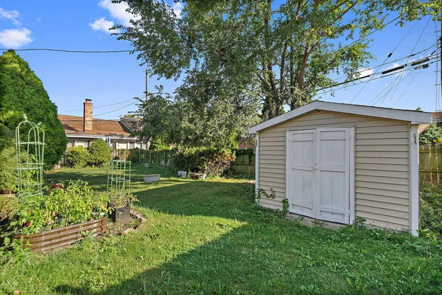 a view of a backyard with barn plants and large trees