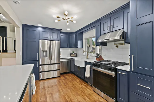 a kitchen with stainless steel appliances granite countertop a stove refrigerator and cabinets