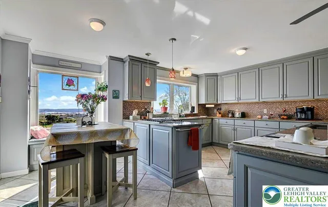a kitchen with stainless steel appliances kitchen island granite countertop a refrigerator and a sink