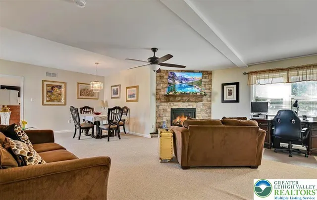 a view of a dining room and livingroom with furniture wooden floor a rug a painting and a chandelier
