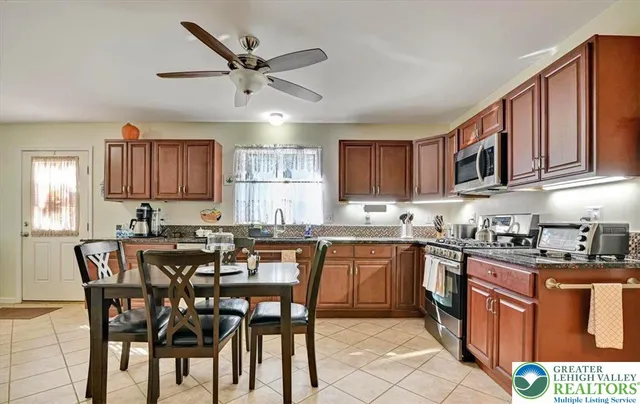 a bathroom with a granite countertop sink a mirror and a toilet