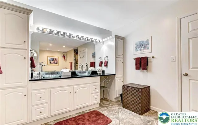 a bathroom with a granite countertop toilet sink and mirror