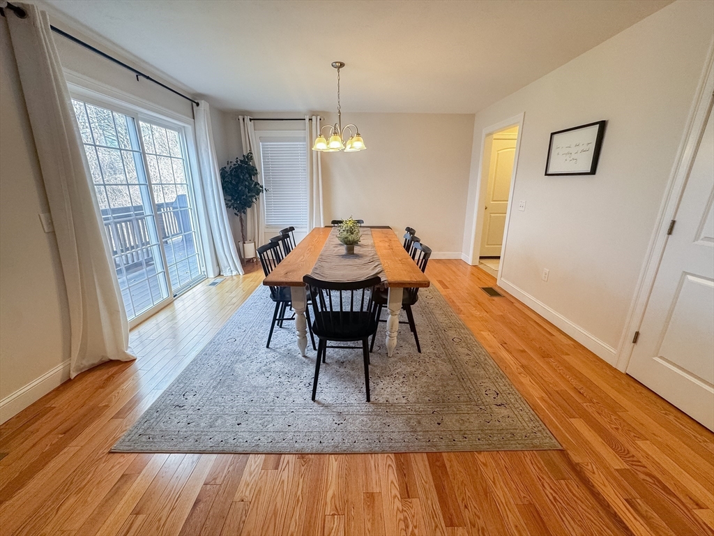 23 Ralph Street Chicopee, MA 01020 - Photo 8 of 42 a dining room with wooden floor and a chandelier