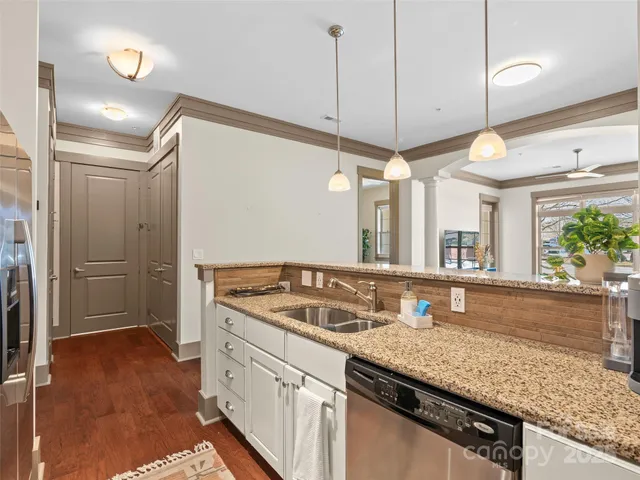 a kitchen with granite countertop a sink a stove and a wooden cabinets