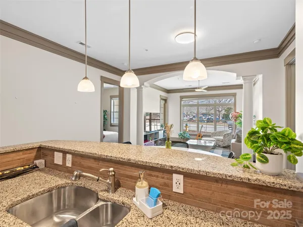 a kitchen with stainless steel appliances granite countertop a refrigerator a stove and a sink