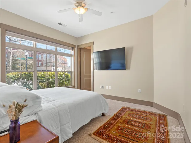 a bedroom with a bed and a large window