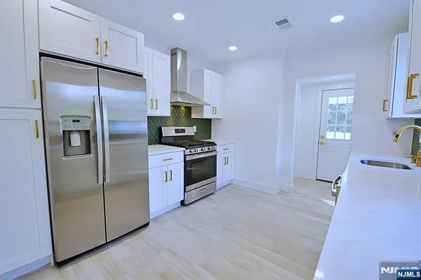 a kitchen with stainless steel appliances granite countertop a refrigerator and a sink