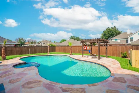 a view of a swimming pool with a garden and trees