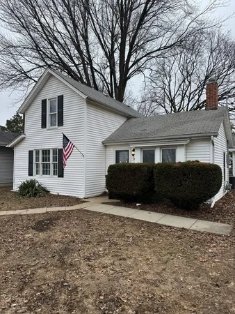 a view of house with yard and sitting area