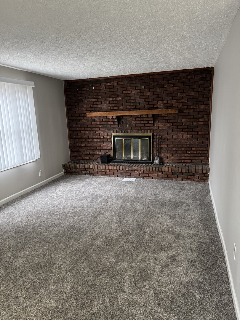 108 East Cleveland Street Heyworth, IL 61745 - Photo 2 of 13 an empty room with a fireplace