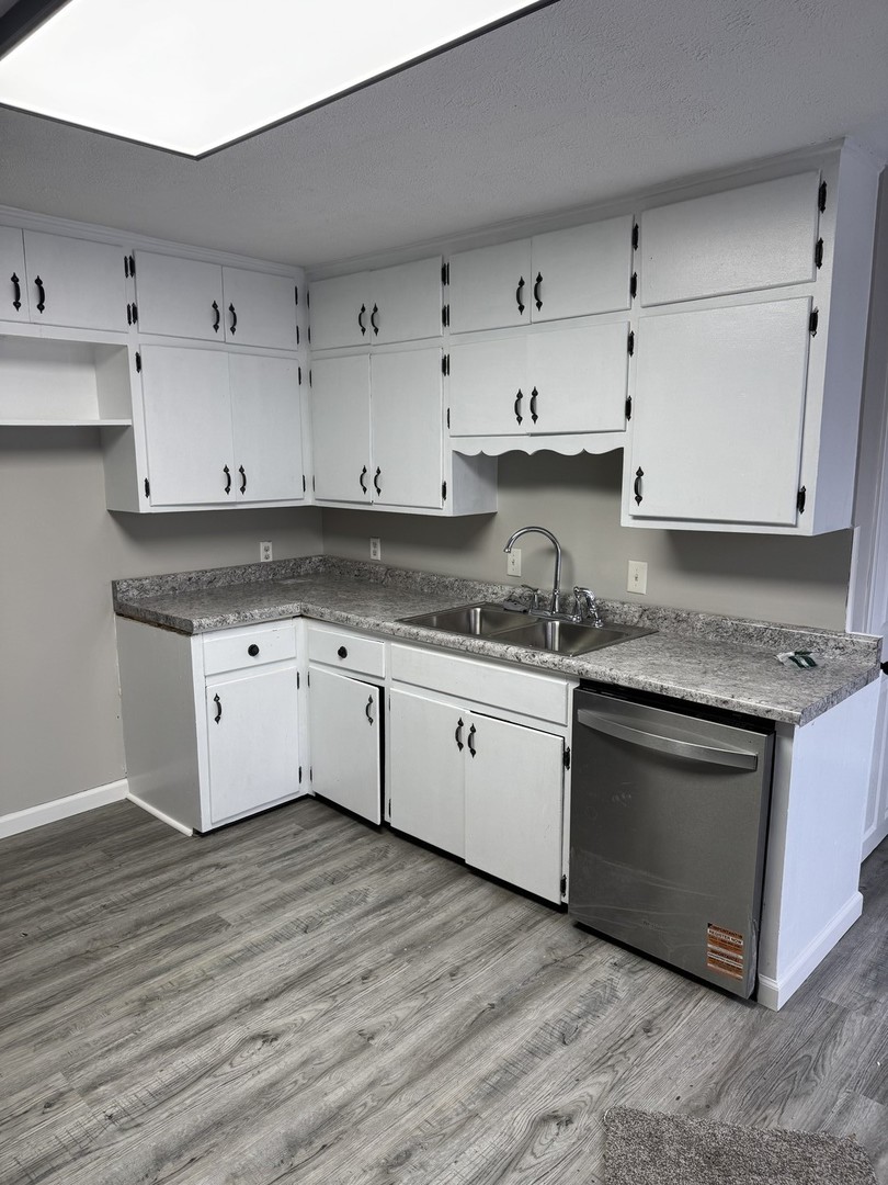 108 East Cleveland Street Heyworth, IL 61745 - Photo 4 of 13 a white kitchen with granite countertop stainless steel appliances and wooden cabinets