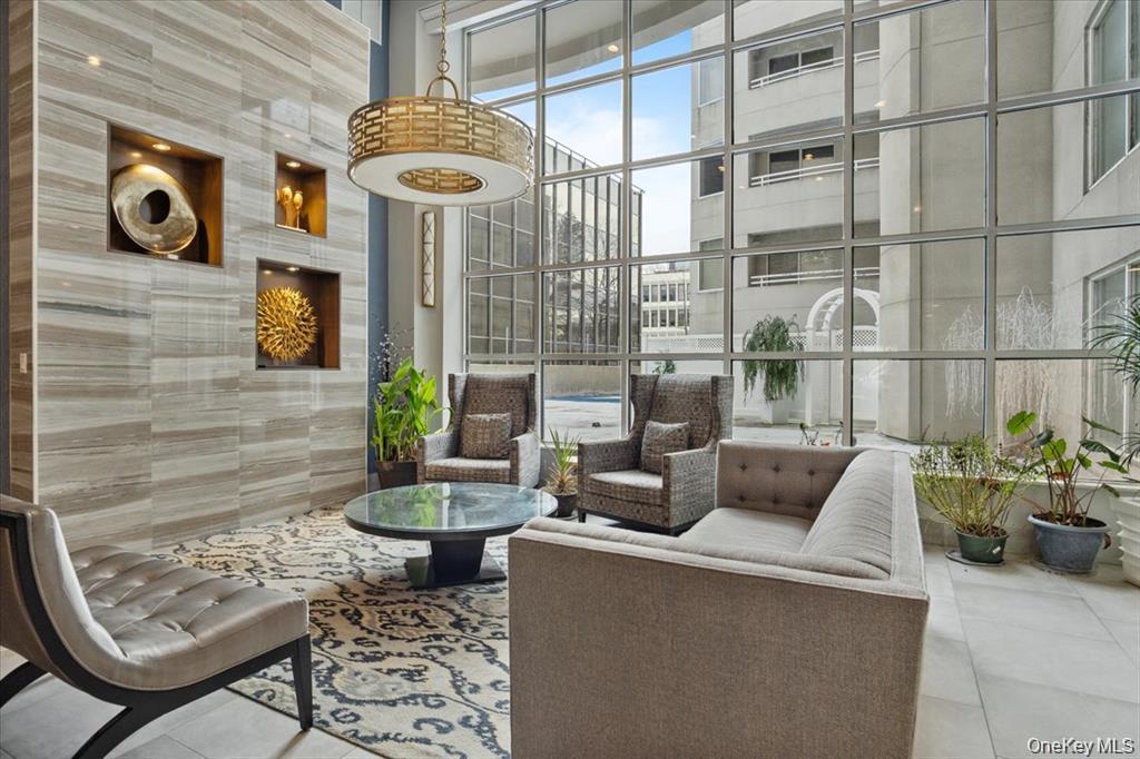 100 Cutter Mill Road, Unit 4G Great Neck, NY 11021 - Photo 1 of 18 Common area with expansive windows and a high ceiling