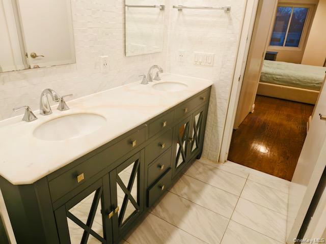 100 Cutter Mill Road, Unit 4G Great Neck, NY 11021 - Photo 12 of 18 Bathroom featuring double vanity, connected bathroom, and tile walls