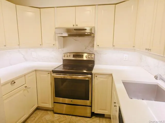 a kitchen with a sink stove and cabinets
