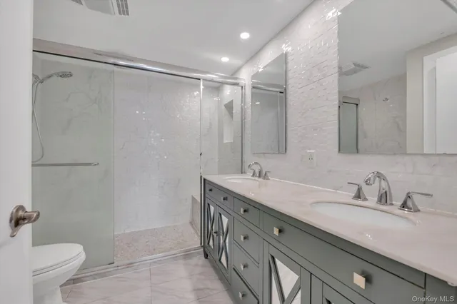 a bathroom with a double vanity sink mirror double and a shower