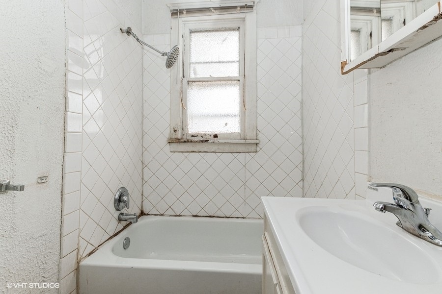 1436 West 110th Place Chicago, IL 60643 - Photo 3 of 10 a bathroom with a white bath tub sitting next to a white sink and a window
