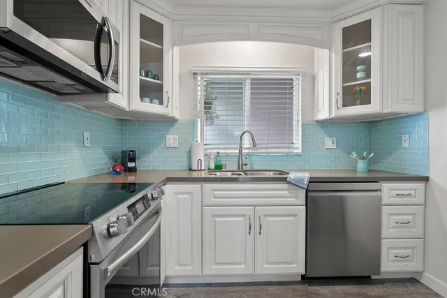 a kitchen with granite countertop a sink stainless steel appliances and cabinets