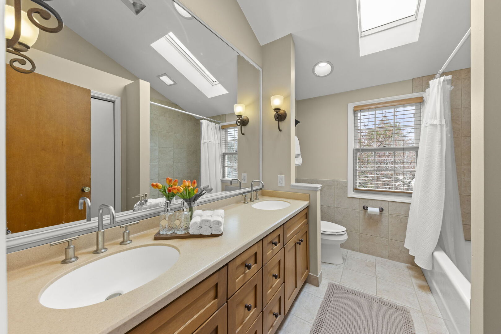 904 Gamon Road Wheaton, IL 60189 - Photo 25 of 47 a bathroom with double vanity sinks a large mirror and a shower