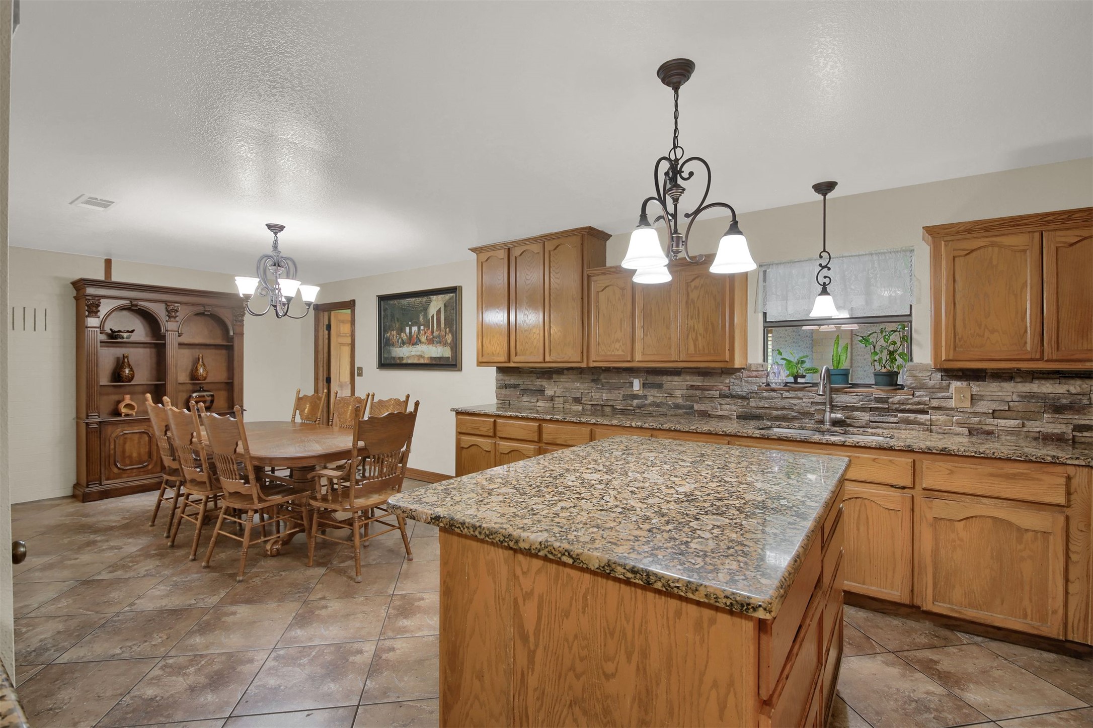 191 Jordan Lane Elgin, TX 78621 - Photo 7 of 29 Natural stone counters and detailed tile floors enrich this functional, open culinary workspace.