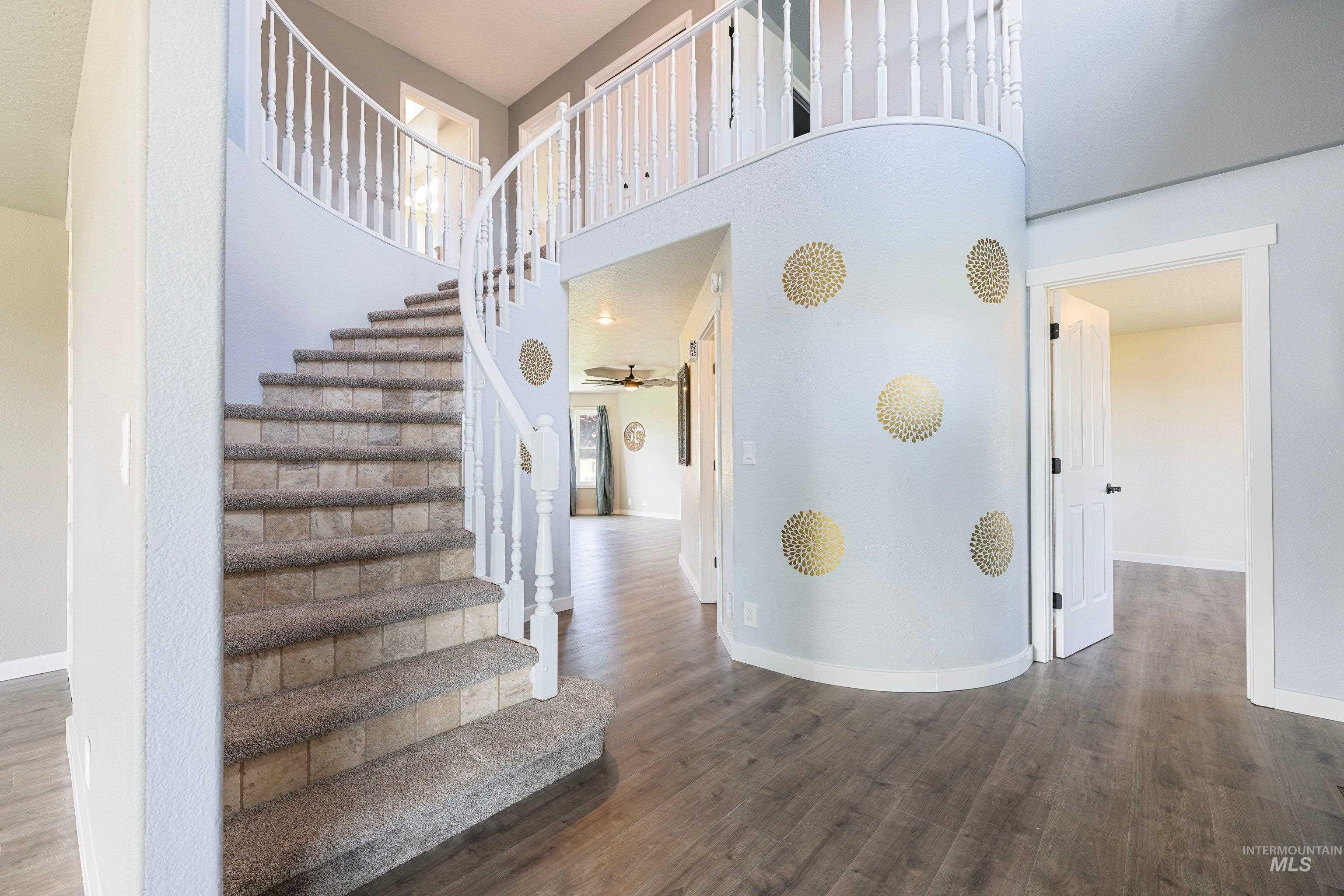 7657 Track Road Nampa, ID 83686 - Photo 5 of 50 Curved staircase with carpeted treads and white spindle railing
