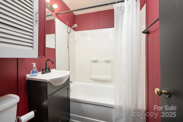 a bathroom with a sink a toilet a mirror and shower