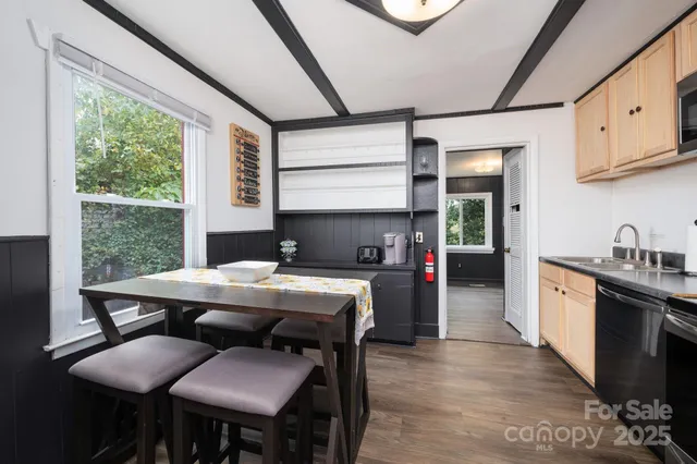 a kitchen with stainless steel appliances granite countertop a stove two chairs next to a window