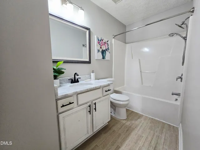 a bathroom with a granite countertop sink toilet a large mirror a shower and a mirror