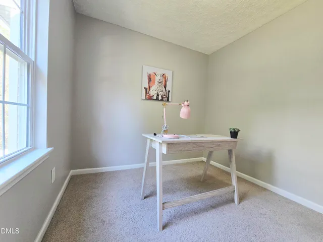 a workspace room with furniture and a window