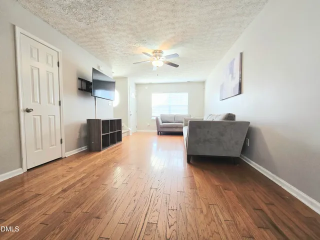 a living room with furniture and a wooden floor