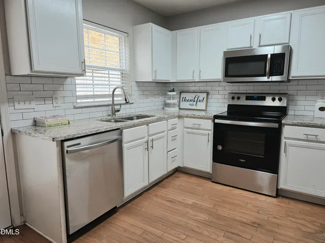 a kitchen with stainless steel appliances granite countertop a stove a sink and a microwave