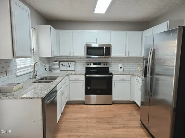 a kitchen with a sink stove and refrigerator