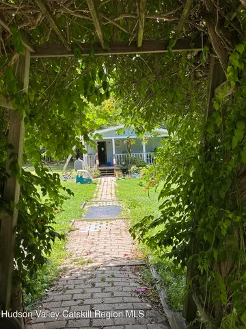 a view of a patio with table and chairs potted plants and floor to ceiling window