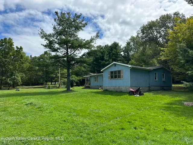 a view of a house with yard and a tree