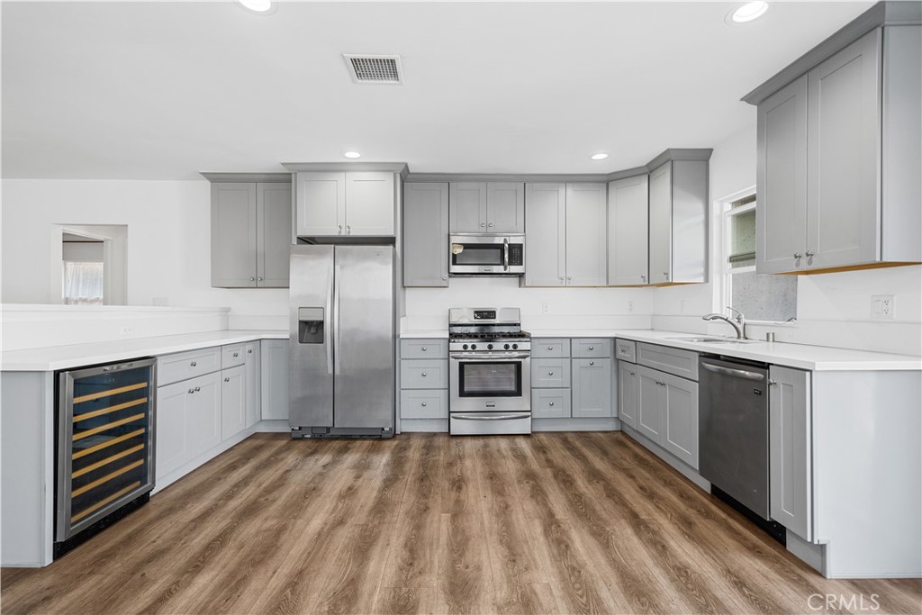 202 Mira Mar Avenue Long Beach, CA 90803 - Photo 14 of 49 a kitchen with granite countertop white cabinets and stainless steel appliances