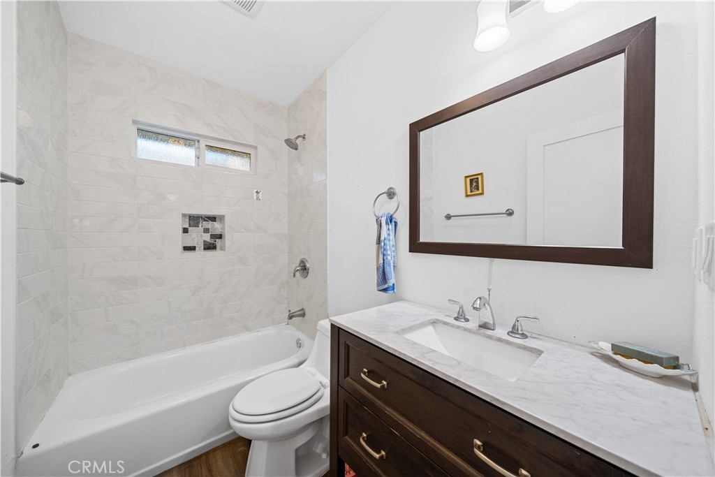 202 Mira Mar Avenue Long Beach, CA 90803 - Photo 20 of 49 a bathroom with a granite countertop toilet sink and a mirror