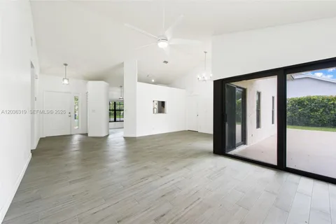 a view of a big room with wooden floor and windows