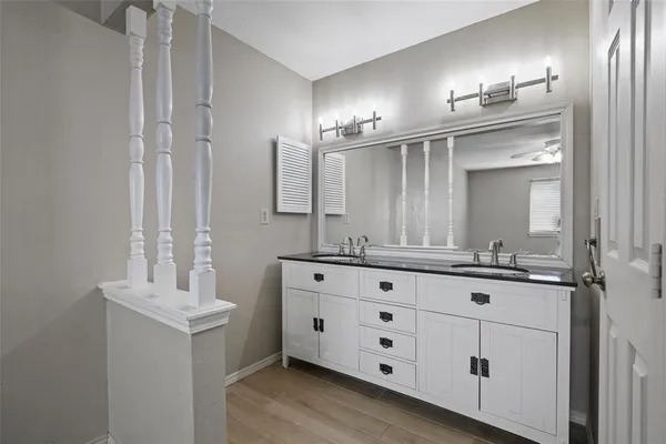 a bathroom with a double vanity sink a mirror and a bathtub