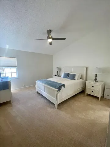 a spacious bedroom with a bed and a chandelier